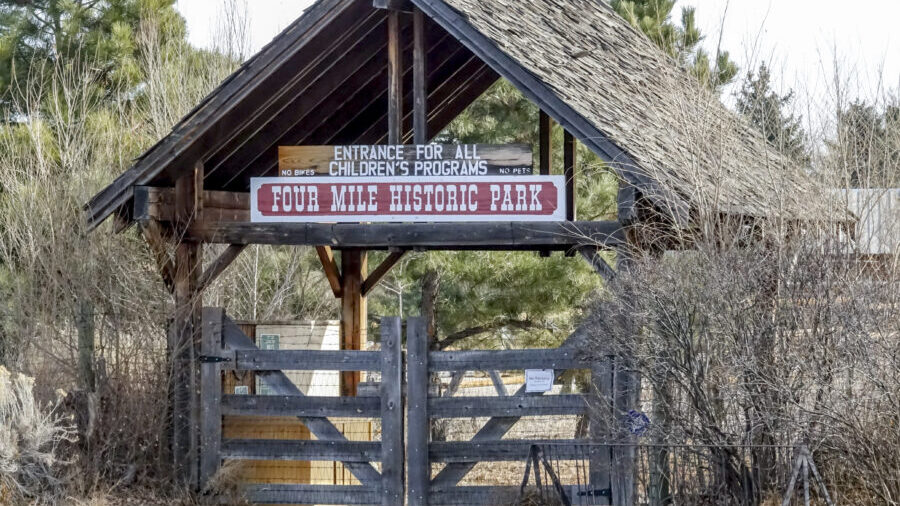 Entrada de madera al Parque Histórico Four Mile; el cartel dice: «Entrada para todos los programas infantiles. Prohibido el acceso a bicicletas y mascotas».
